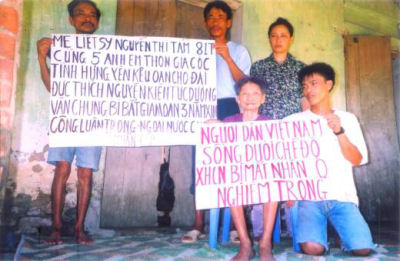 Thich Nguyen Kien’s mother, Nguyen Thi Tam (sitting) and 4 Buddhists carrying posters of protest. Mrs Tam’s poster says : “Vietnamese people living under the communist regime are seriously deprived of their human rights”