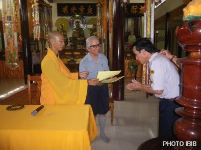 Một Huynh trưởng nhận bằng Chứng nhận hoàn mãn Trại Vạn Hạnh từ tay Thượng toạ Thích Minh Quang trước mặt Vụ trưởng Lê Công Cầu