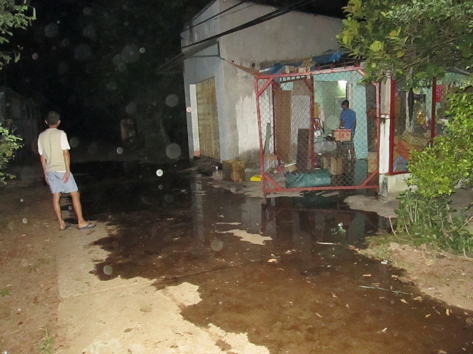 Foul-smelling water runs down the road outside Huynh Ngoc Tuan’s home