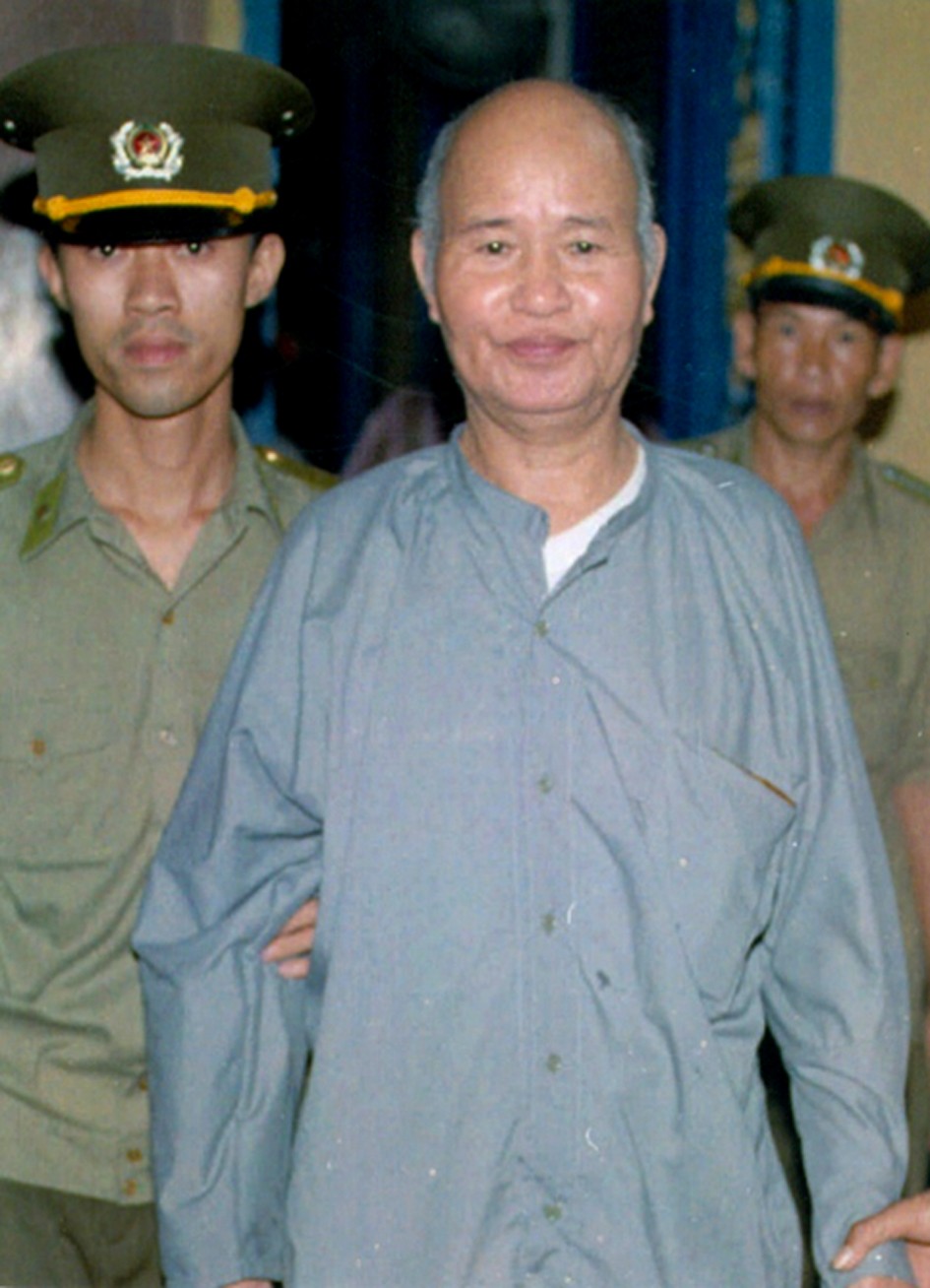 Hai Công an dẫn HT Thích Quảng Độ ra trước Toà án Nhân Dân Tp Hồ Chì Minh tháng 8 năm 1995 xử tội “đi cứu trợ nạn nhân lũ lụt ở đồng bằng Sông Cửu Long”.